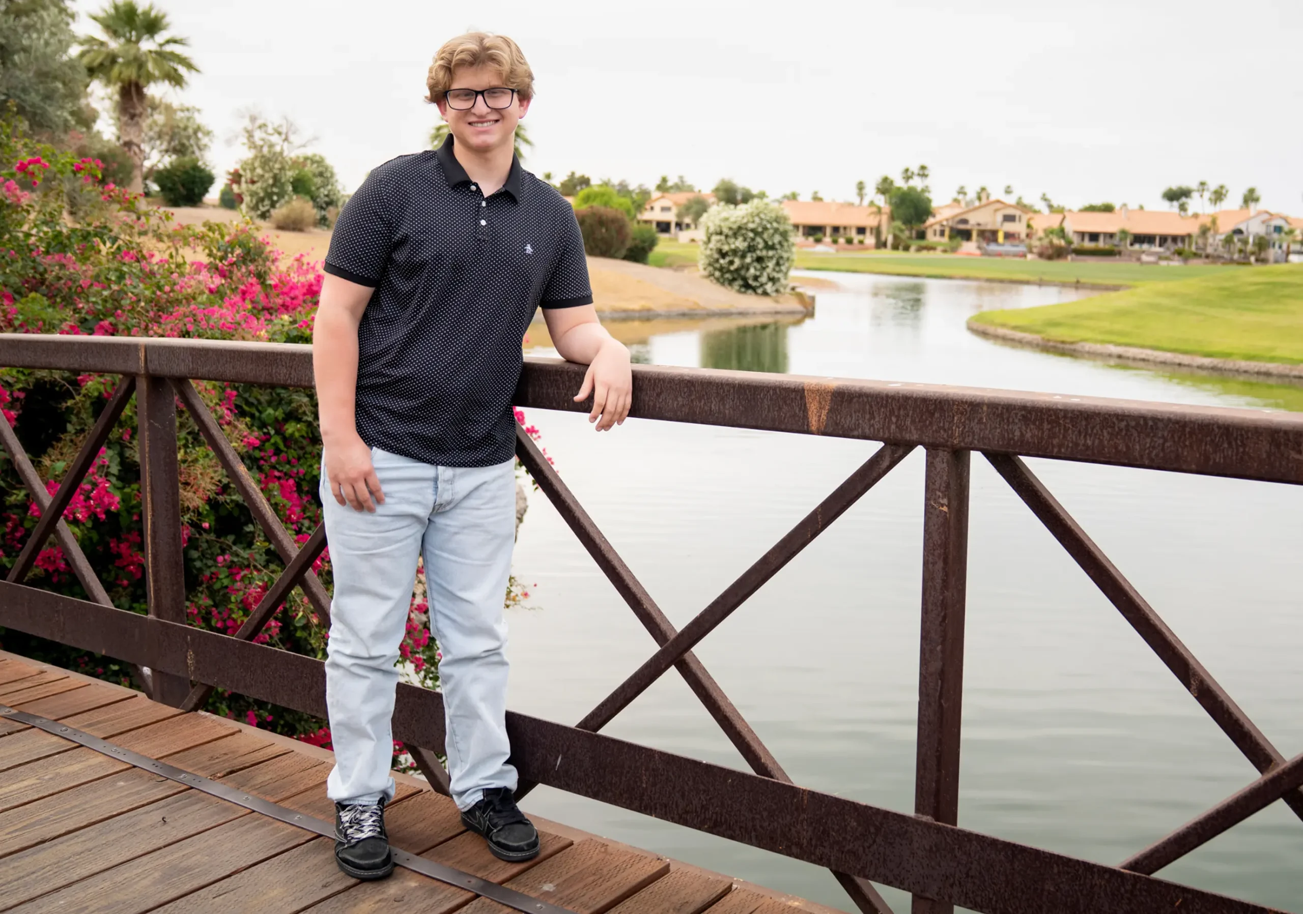 Jackson standing on a bridge beside a lake